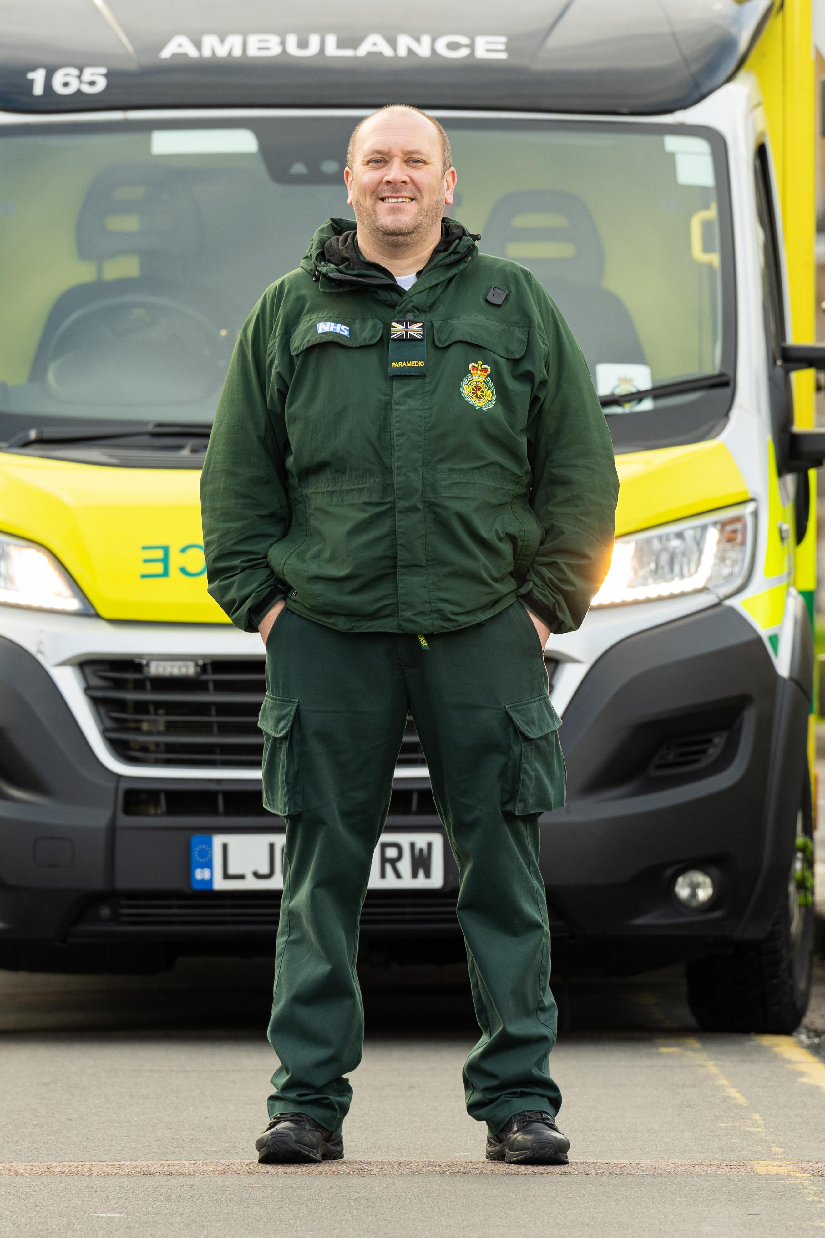 A paramedic stands in front of an ambulance