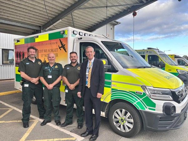 Four men standing in front of a remembrance ambulance