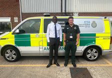 a picture of an mp and EEAST staff member standing on the side of a stationery ambulance