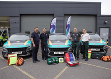 Essex Freemasons with CFR and charity representative standing in front of three CFR cars