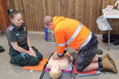An EEAST staff member demonstrates CPR to a member of the public during a lifesaving skills event at Colchester Zoological Society.