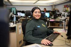 Call handler at computer desk taking a call