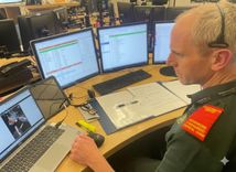 A clinician at a desk with a video call open to give CPR instructions