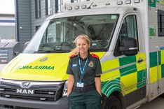 Jemma Varela in ambulance uniform in front of an ambulance at Bury Ambulance Hub