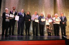 Leisure centre staff with EEAST staff lined up standing on a stage with their commendations
