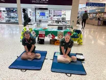 Two paramedics demonstrate CPR on manikins in a shopping centre
