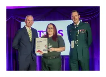 Megan Kelly, in ambulance uniform, receives her Stars of EEAST award from EEAST CEO Neill Moloney, wearing a suit, and EEAST Chief Operating Officer Darren Meads, who is wearing ambulance dress uniform