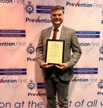  A proud well dressed man in a suit holding his award