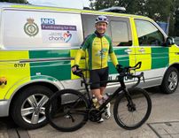 Stuart Howlett with his bike in front of an ambulance vehicle 