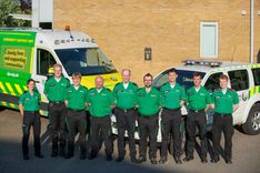 Nine people in St John Ambulance uniform stand in front of two vehicles as a co-responder scheme is launched with the East of England Ambulance Service