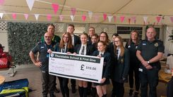 Year 10 pupils in uniform with members of the Tiptree Community First Responders, in the green ambulance uniform